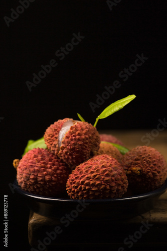 Wallpaper Mural Small ripe tropical lychee berries on a black plate in a minimalist style, low key Torontodigital.ca