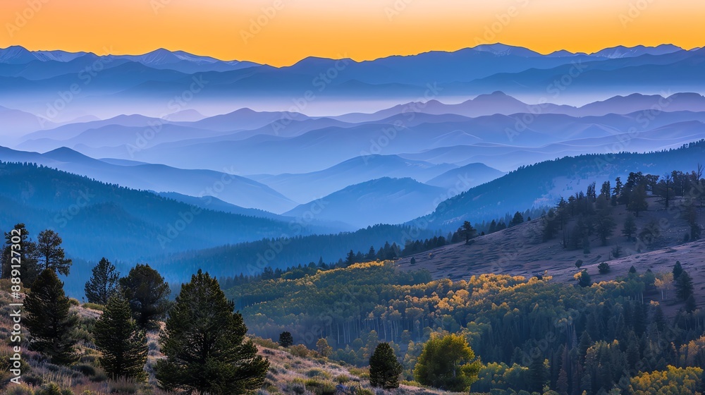 Obraz premium A view of a mountainous landscape with a warm sunset sky.