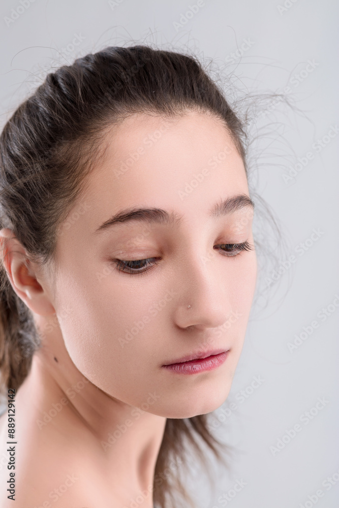Young woman with natural beauty is posing on grey background Young woman with natural beauty is posing on grey background