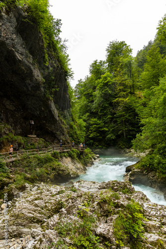 Vintgar Gorges Park a few km from Lake Bled, Slovenia. Wooden walkways accompany the path above the river rapids and waterfalls. River hits rocks and creates fog.Adventure family holidays. Freshness.