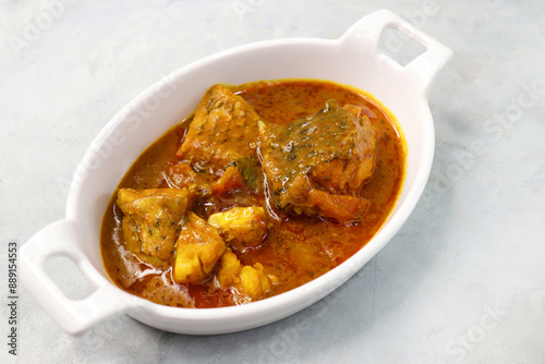 Indian Food. Homemade Spicy and tangy dadha or threadfin fish curry. Famous Maharshtrian red fish curry or kalvan, made with tomato, tamarind, chili, garlic, and other Indian spices. Copy space. photo