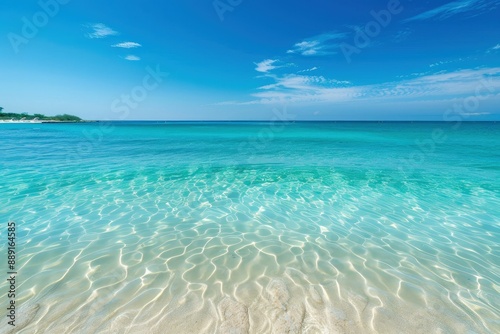 a sandy beach with clear blue water under a blue sky
