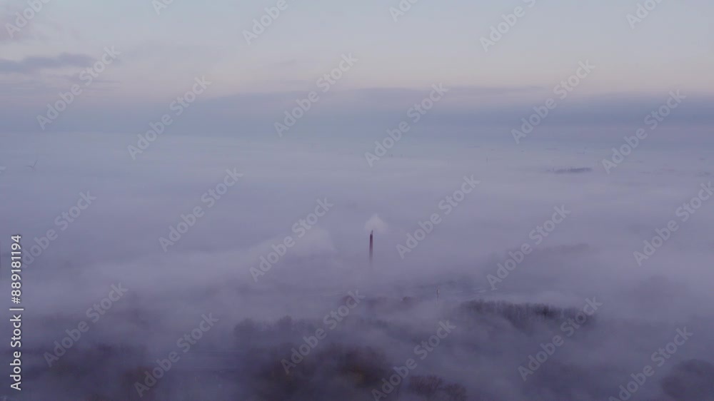 Aerial view of foggy morning with factory chimneys emitting smoke in Bolsward, Friesland, Netherlands. Aerial view of foggy morning with factory chimneys emitting smoke in Bolsward, Friesland, Netherlands.