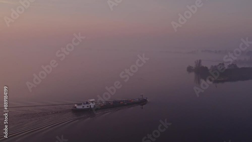 Aerial view of foggy countryside lake with vessel at sunrise, Jistrum, Friesland, Netherlands. photo