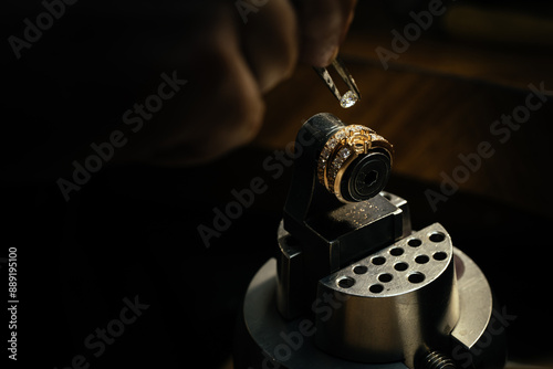 Jeweler puts diamond to golden wedding luxury ring.
