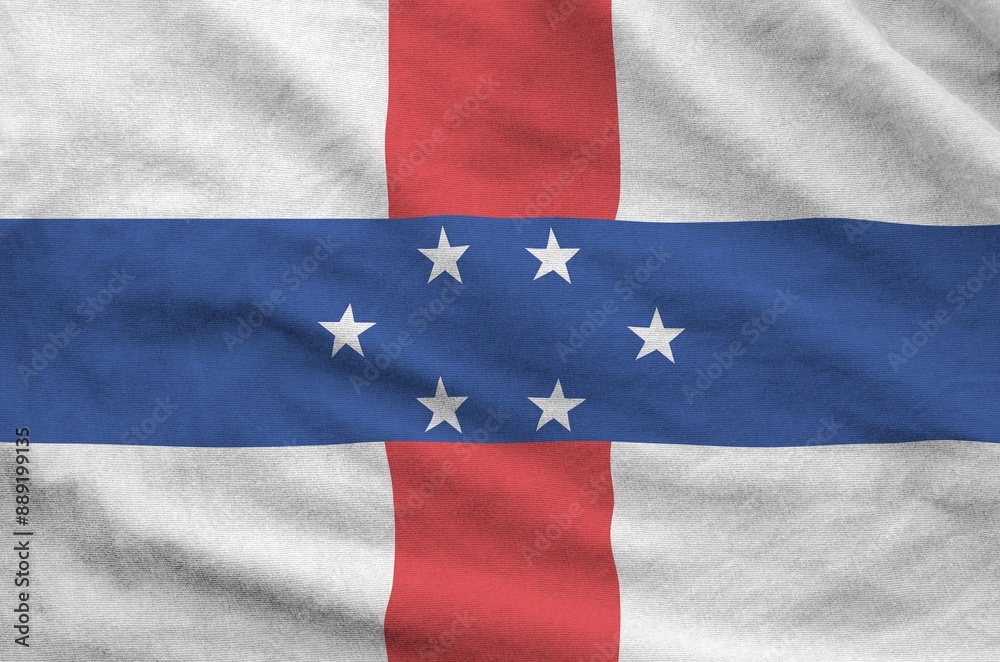 Netherlands Antilles flag depicted on folded wavy fabric of old cloth close up Netherlands Antilles flag depicted on folded wavy fabric of old cloth close up