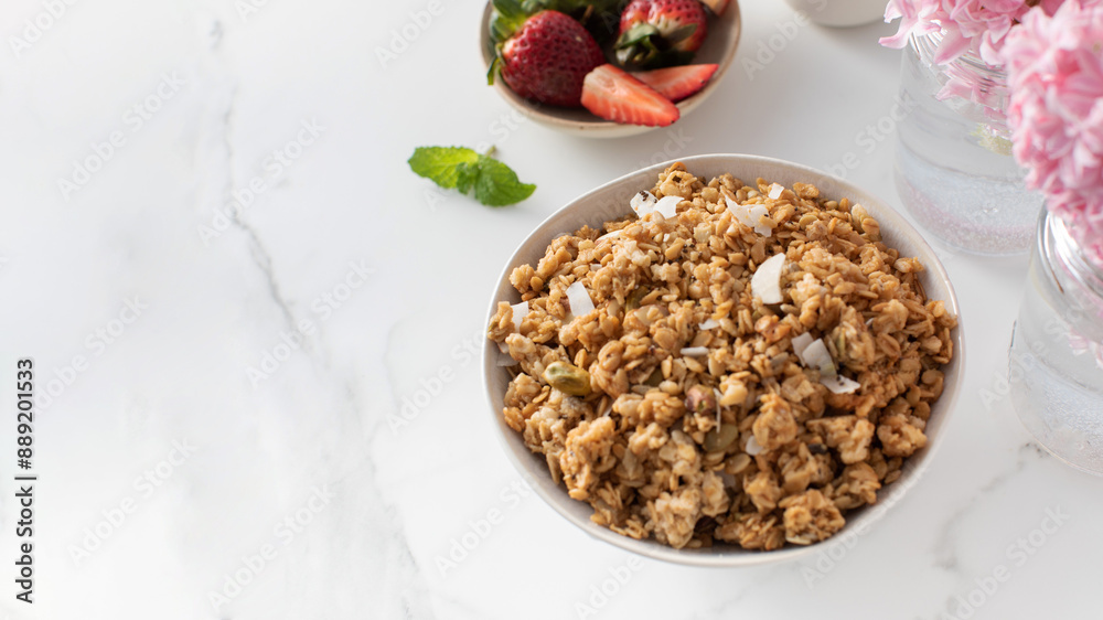 Crispy homemade granola with sliced almonds in a bowl with strawberries. Healthy eating. Copy space Crispy homemade granola with sliced almonds in a bowl with strawberries. Healthy eating. Copy space