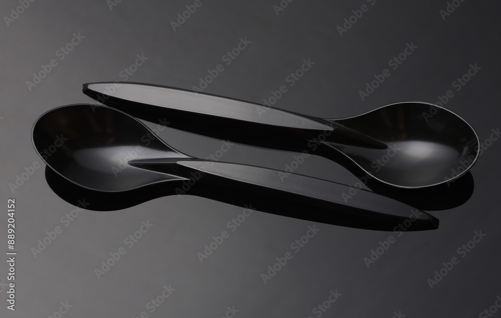 Black plastic spoons on a dark background Black plastic spoons on a dark background