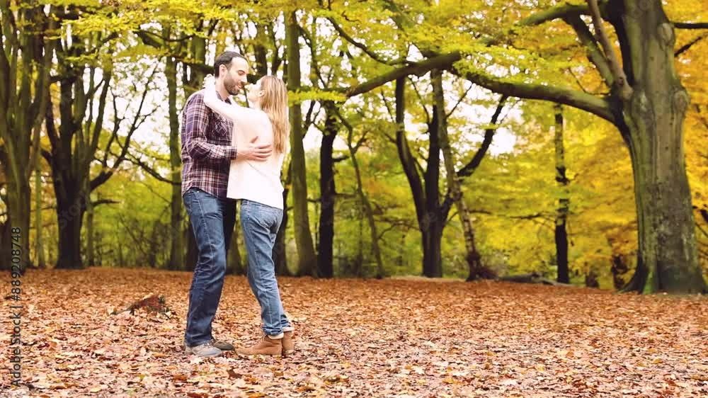 Happy couple hugging and cuddling in the wood with autumn foliage colors Happy couple hugging and cuddling in the wood with autumn foliage colors