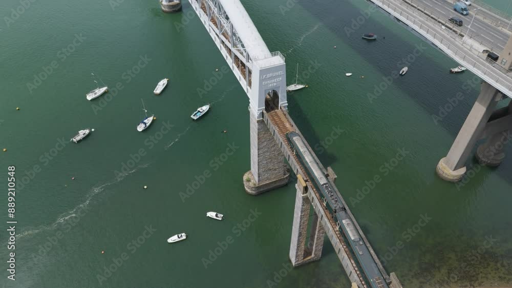 Aerial view of a train beginning to cross the Royal Albert Bridge from Plymouth to Saltash, UK, highlighting the engineering marvel
