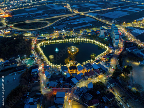 Gyo-dong, Gimcheon-si, Gyeongsangbuk-do, South Korea - March 29, 2023: Aerial and night view of houses of a village with Yeonhwaji Reservoir surrounded by white cherry blossom
 photo