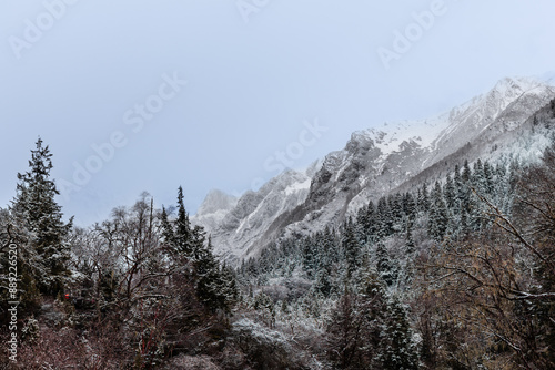 Misty view of snowy mountain ranges in Changping valley of Siguniangshan National Park in Sichuan China in early spring. photo