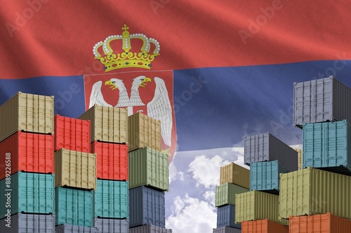 Serbia flag and big stack of shipping cargo containers in docks with sky background close up photo