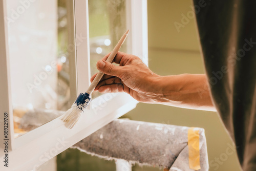 Maler streich Fenster mit Pinsel photo