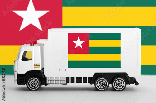 Togo flag depicted on side wall of white delivery van close up. Shipping and local delivery concept photo