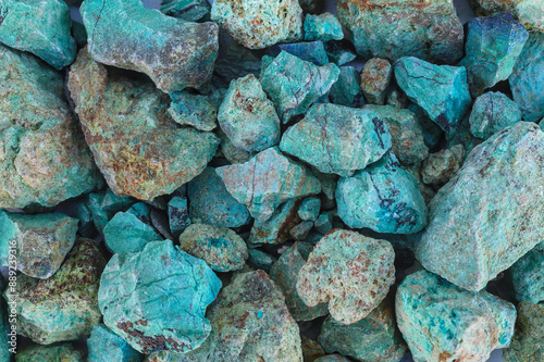 Foto Blue green copper (Cu) oxide ore, held in hand, against background of ore that is out of focus