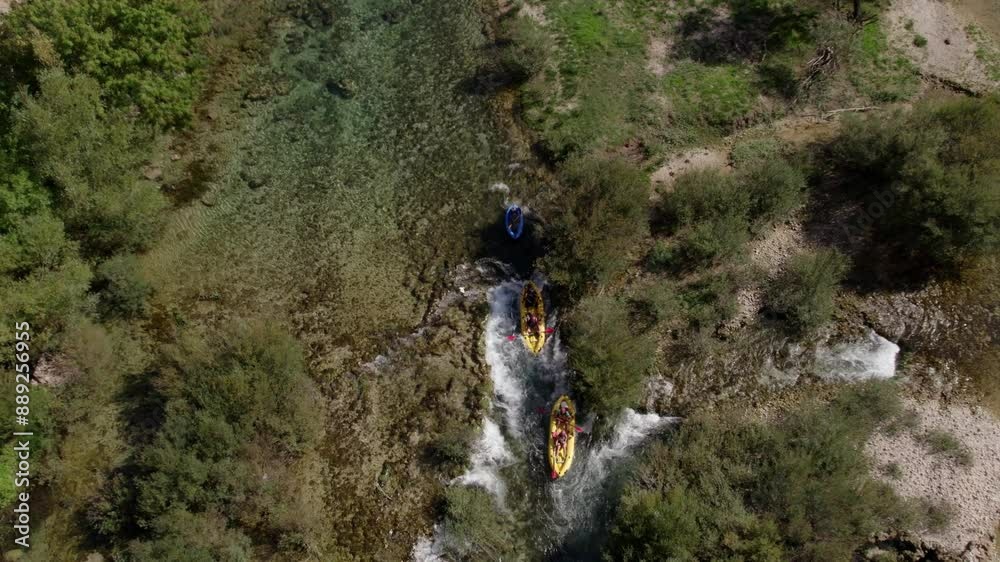 Aerial view of serene river with kayaks and canoes, lush forest, and cascading waterfall, Zrmanja, Croatia. Aerial view of serene river with kayaks and canoes, lush forest, and cascading waterfall, Zrmanja, Croatia.