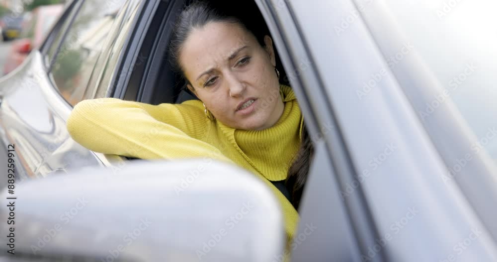Woman driving a car and getting annoyed stuck in traffic