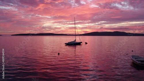 Aerial view of colourful sailboat sailing in serene sea at sunset, Krapanj Island, Croatia. photo