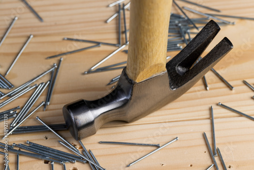 nails with small caps and an iron hammer on boards photo