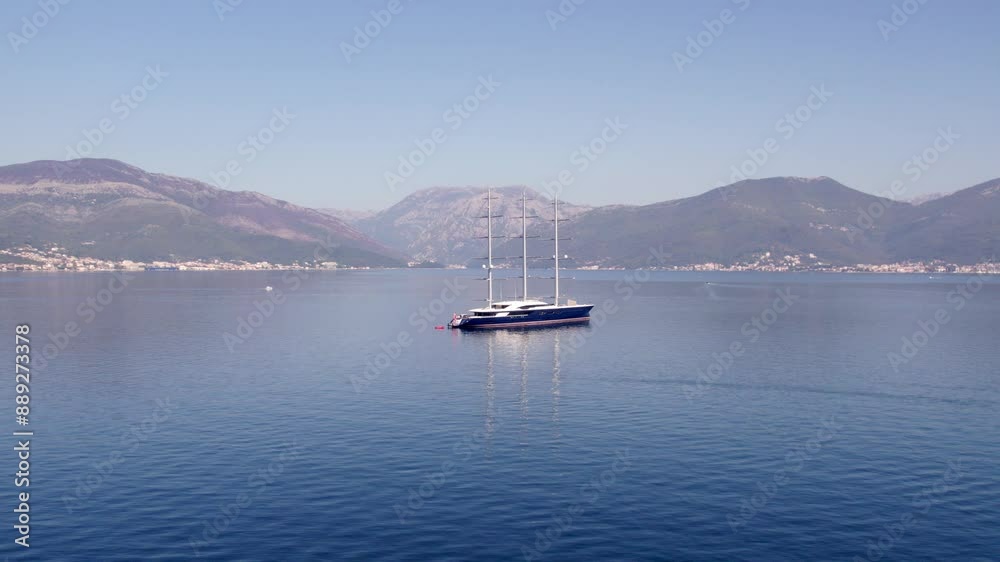 Aerial view of mega yacht anchored in calm Adriatic Sea with mountain range in Kotor Bay, Montenegro. Aerial view of mega yacht anchored in calm Adriatic Sea with mountain range in Kotor Bay, Montenegro.