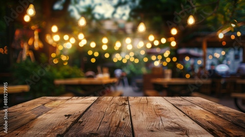 The empty wooden table of a party in a backyard at night with a blurry background: Stock