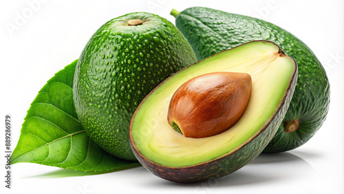 Three green avocados, one sliced open to reveal its seed and flesh, are arranged on a white surface with a single green leaf photo