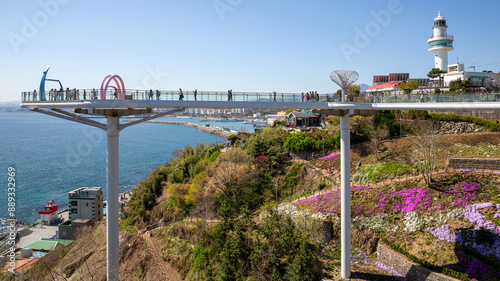 Donghae-si, Gangwon-do, South Korea - April 9, 2023: Spring view of tourists on observatory with pillars against Mukho Lighthouse on the hill at Dojebigol Sky Valley
 photo