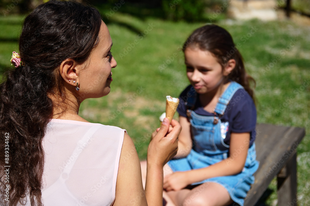 Mother and daughter enjoying ice cream on a sunny day in the park Mother and daughter enjoying ice cream on a sunny day in the park