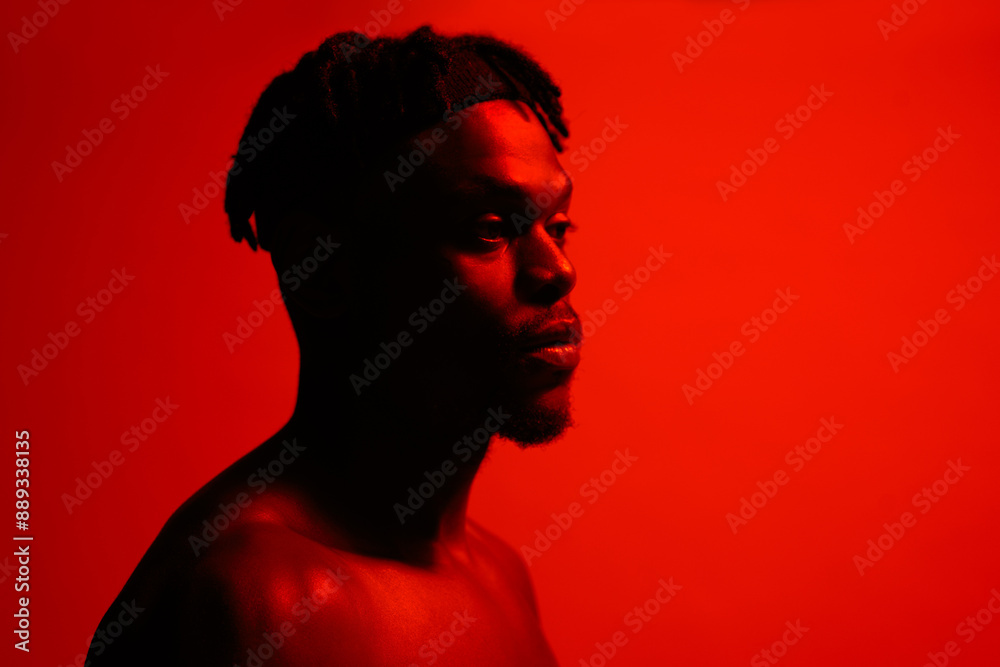 Black man, serious and red neon with studio background for sports, fitness and training. Male person, profile and athlete for exercise or workout for self care, wellness and wellbeing in confidence Black man, serious and red neon with studio background for sports, fitness and training. Male person, profile and athlete for exercise or workout for self care, wellness and wellbeing in confidence