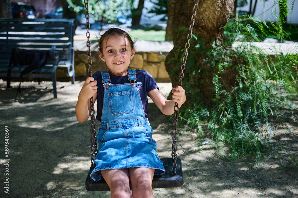 Happy young girl enjoying a sunny day on a swing in the park Happy young girl enjoying a sunny day on a swing in the park