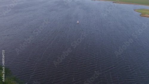 Aerial view of serene Lake Fluessen at sunset with sailing boat, Koudum, Friesland, Netherlands. photo