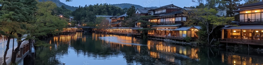 A river with a town on the other side. The town is lit up at night. The water is calm and the reflection of the lights on the water is beautiful A river with a town on the other side. The town is lit up at night. The water is calm and the reflection of the lights on the water is beautiful