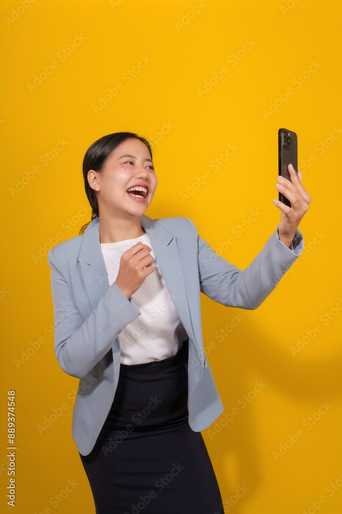 Businesswoman, dressed in a blazer, is laughing with joy while looking at her phone, suggesting she has received positive news Businesswoman, dressed in a blazer, is laughing with joy while looking at her phone, suggesting she has received positive news