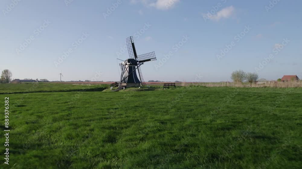 Aerial view of colourful tulip fields and windmill in meadow, Workum, Netherlands. Aerial view of colourful tulip fields and windmill in meadow, Workum, Netherlands.