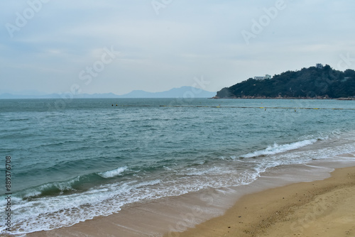 Close-up of soft waves sand beach and blue sea. Texture of water, white foam waves. Seascape, Sea background, Sea water with copy space, summer vacation concept. 