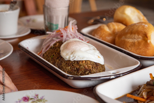 Tacu tacu with fried egg Peruvian breakfast food table with lomo saltado and pejerrey sandwich photo