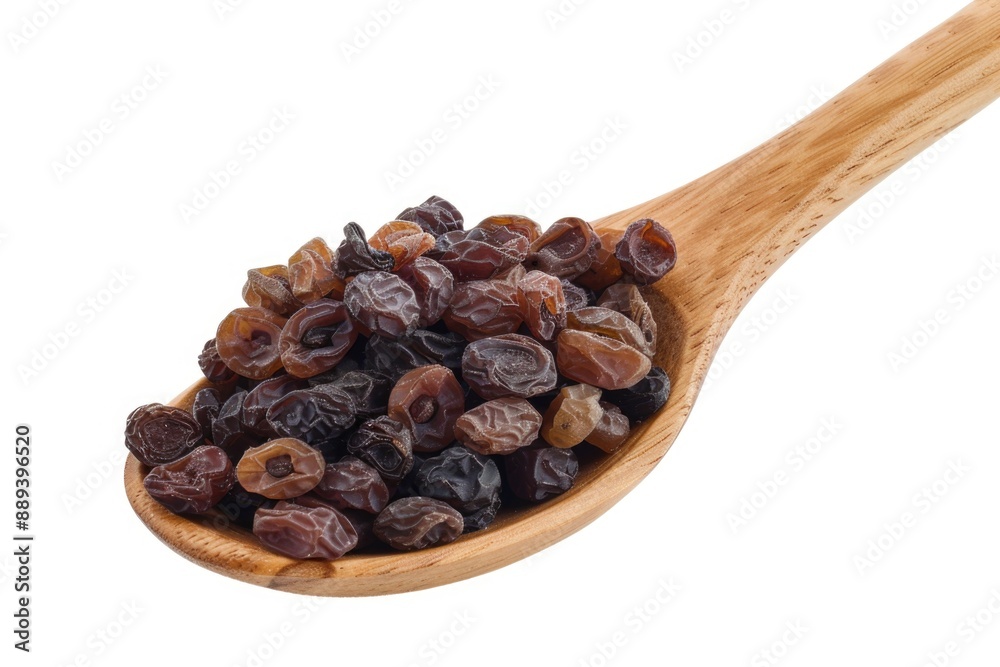 A wooden spoon filled with golden raisins on a white background A wooden spoon filled with golden raisins on a white background