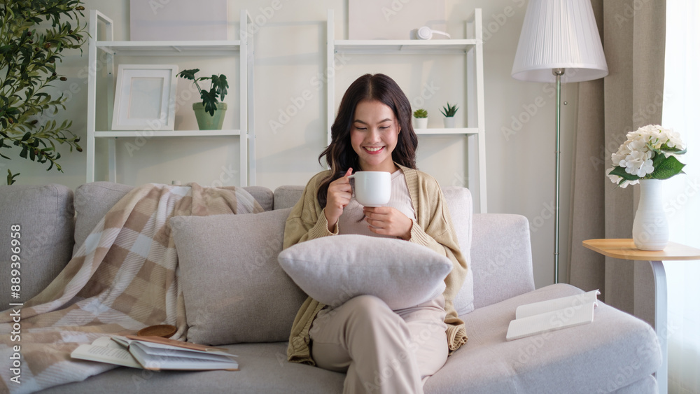 Relaxed young woman sitting on sofa and drinking hot coffee, enjoying weekend at home. Relaxed young woman sitting on sofa and drinking hot coffee, enjoying weekend at home.