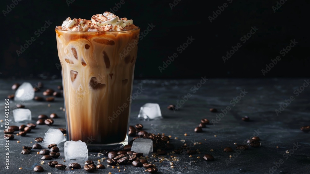 Iced coffee with cream, ice cubes, and beans in a tall glass on a dark concrete surface, set against a black backdrop with cup Iced coffee with cream, ice cubes, and beans in a tall glass on a dark concrete surface, set against a black backdrop with cup