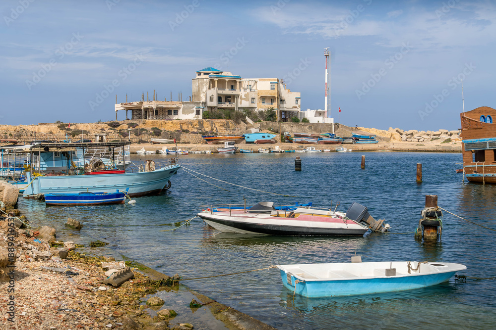 Obraz premium The fishing boats in Monastir, Tunisia, are in the bay of Qaraiya beach during the summer day in North Africa. 