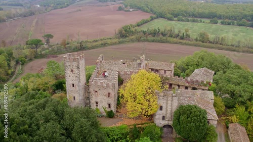 Aerial view of medieval castle surrounded by greenery and fields, Castello di Montalto, Tuscany, Italy.