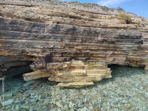 Layered Rock Formation by Clear Waters, Symbolizing the Depth and Complexity of Nature's Timeless Beauty photo