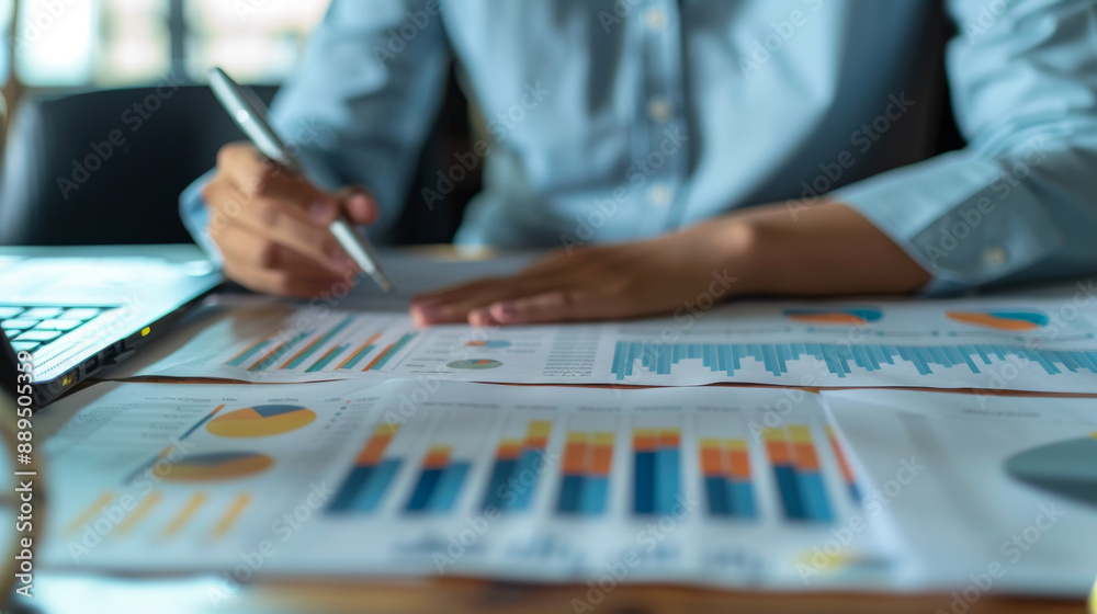 Businessperson working on paperwork with graph and chart Businessperson working on paperwork with graph and chart