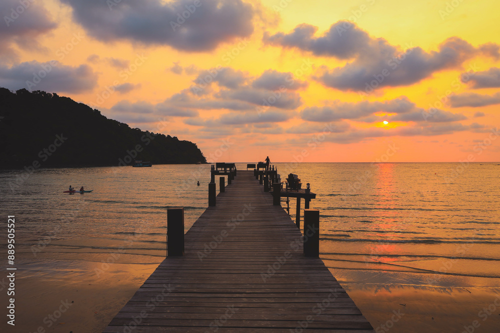 Obraz premium Wooden bridge towards to the sea at sunset, Thailand. Travel and Holiday concept.