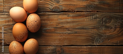 Top-down image of eggs on a wooden table with a background suitable for text placement. image with copy space