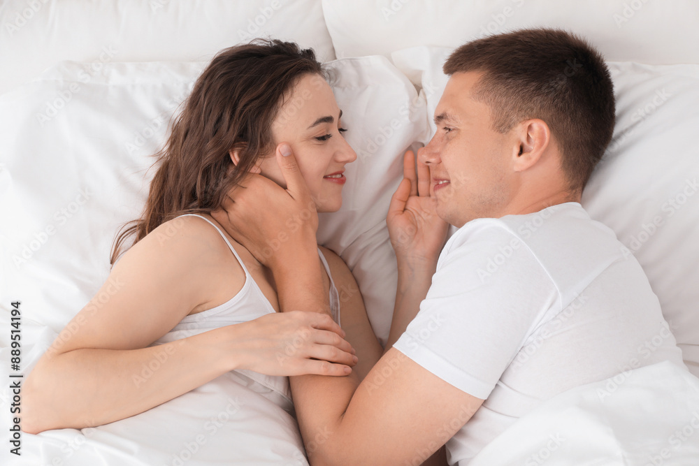 Lovely couple spending time together in bed, top view Lovely couple spending time together in bed, top view