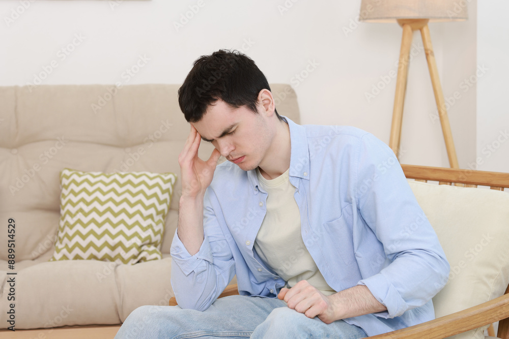 Sad man suffering from headache at home Sad man suffering from headache at home