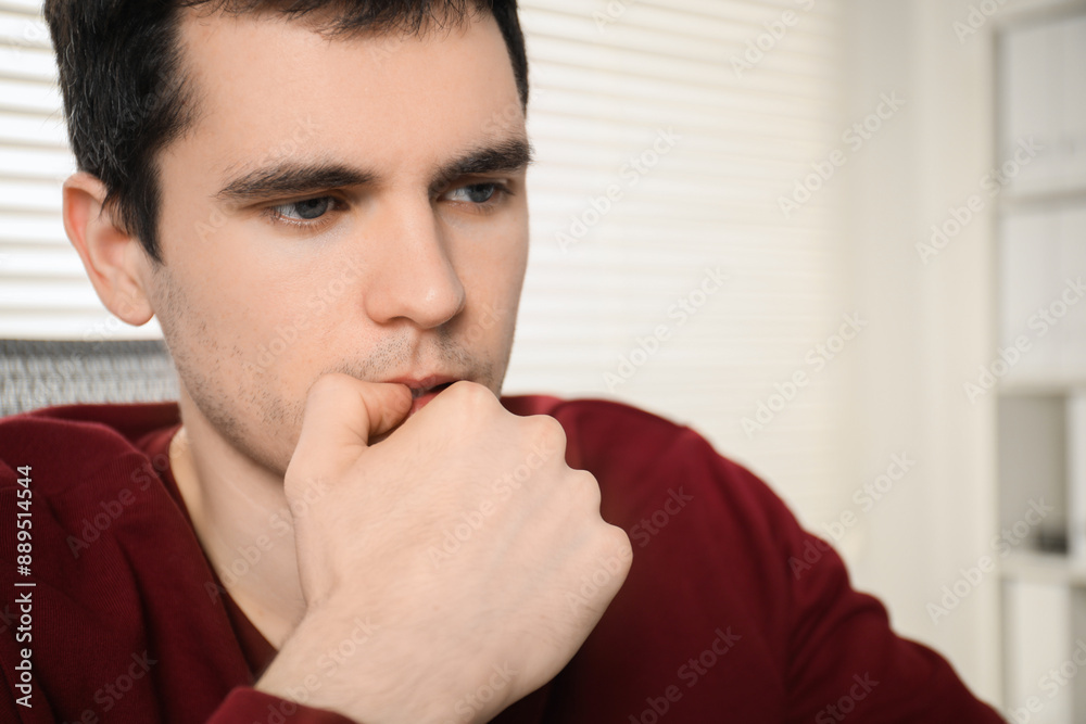Embarrassed young man in office, closeup view
