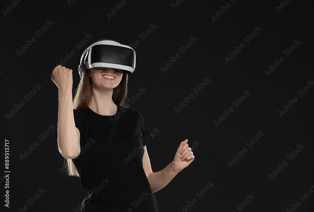 Smiling woman using virtual reality headset on black background, space for text Smiling woman using virtual reality headset on black background, space for text